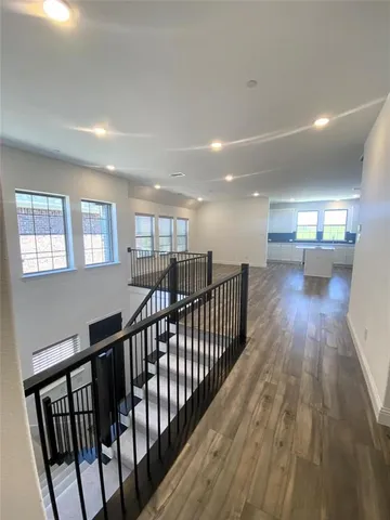 a kitchen with stainless steel appliances granite countertop a refrigerator a stove and a sink with wooden floors