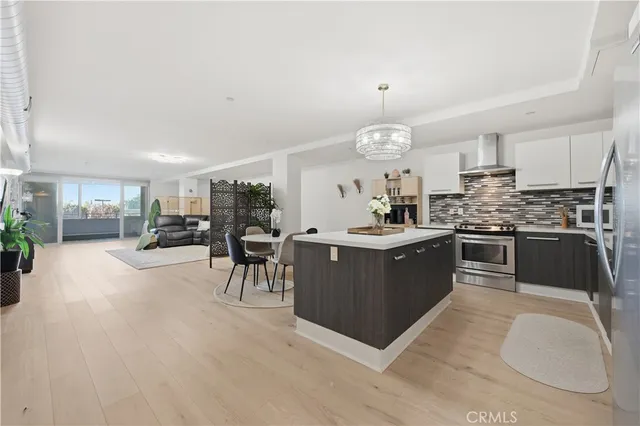 a kitchen with stainless steel appliances granite countertop a stove top oven a sink a counter space and cabinets