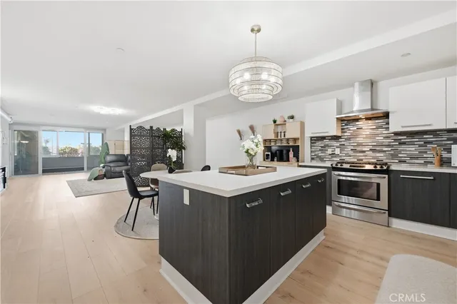 a kitchen with a stove a counter space a sink and cabinets