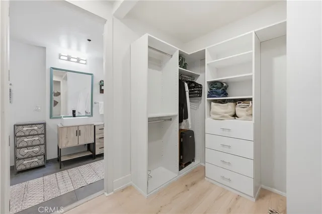 walk in closet with white cabinets
