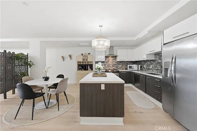 a kitchen with stainless steel appliances granite countertop a sink a stove and a refrigerator