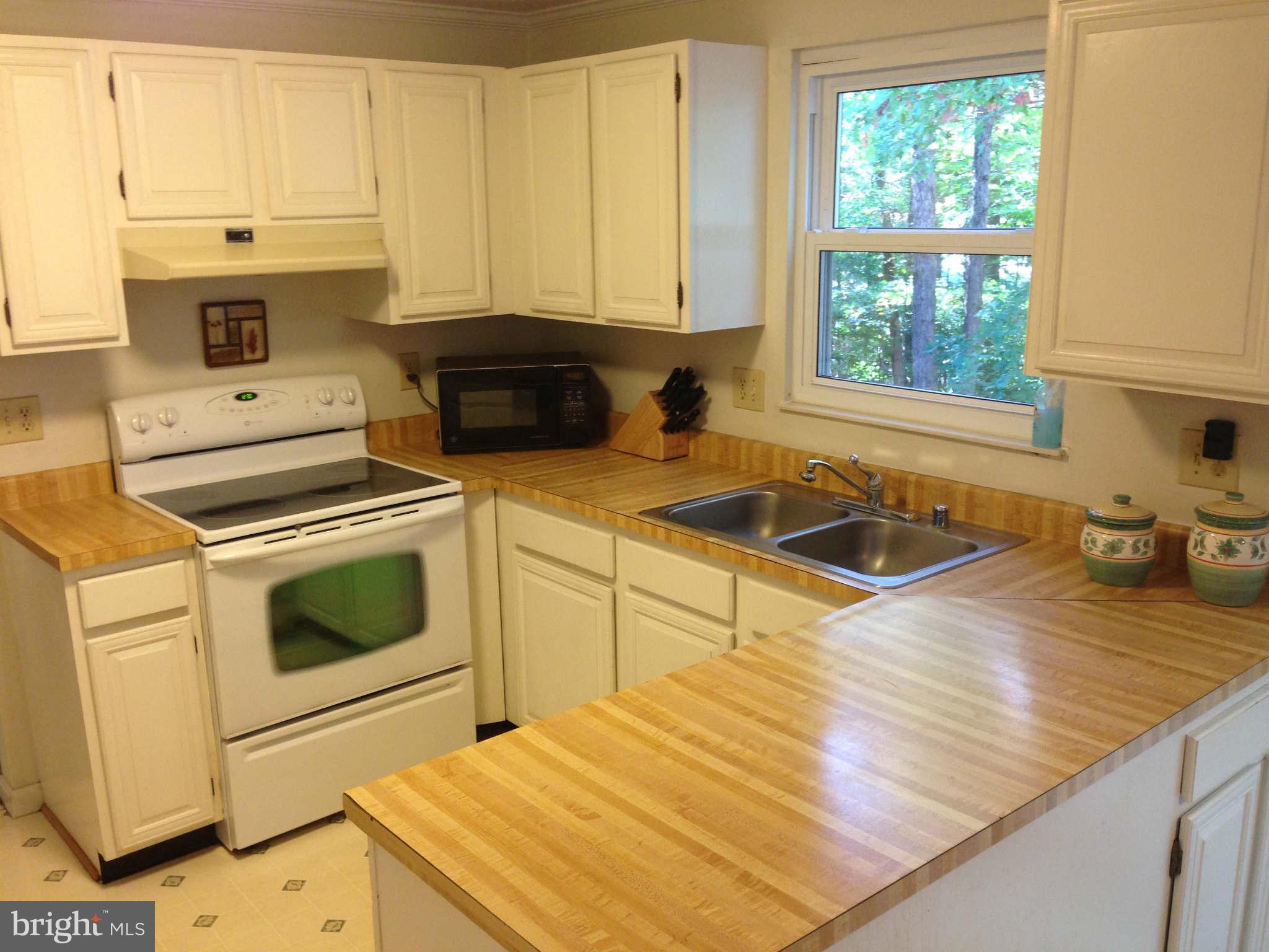 8066 Athena Street Springfield, VA 22153 - Photo 11 of 30 a kitchen with a stove a sink and a cabinets