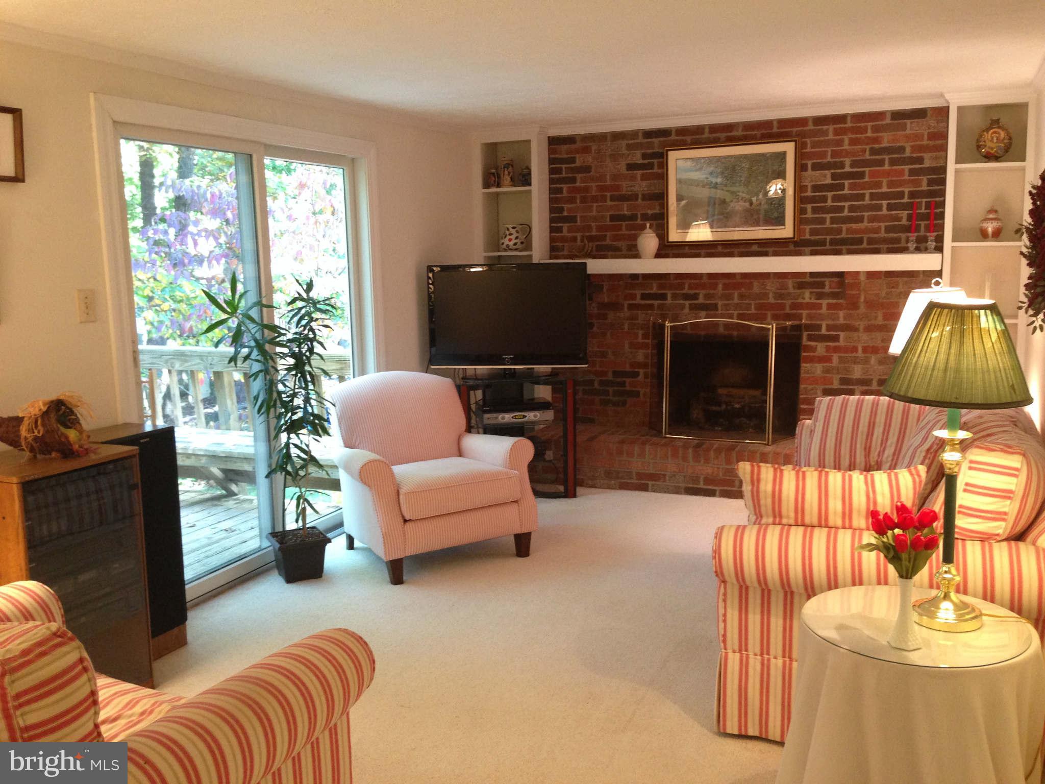 8066 Athena Street Springfield, VA 22153 - Photo 15 of 30 a living room with furniture a fireplace and a large window
