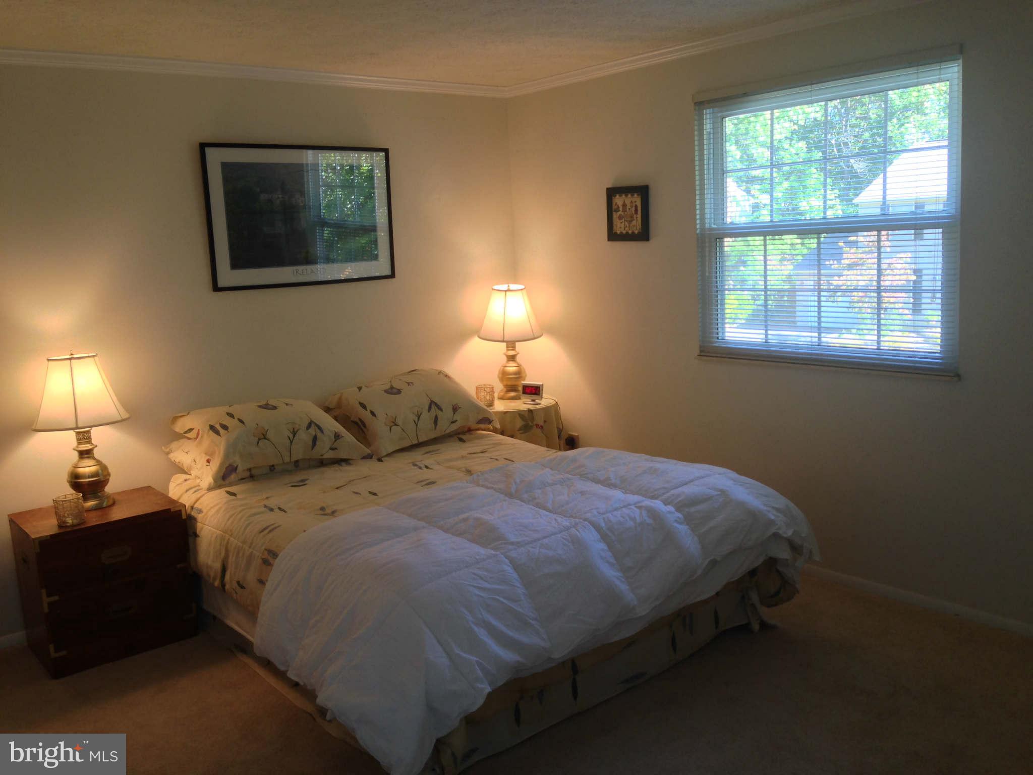 8066 Athena Street Springfield, VA 22153 - Photo 21 of 30 a bed sitting in a bedroom next to a window