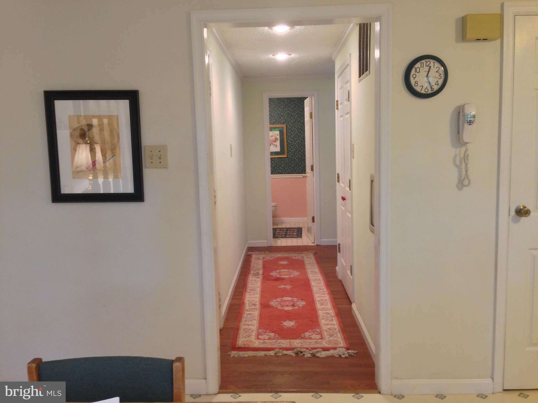 8066 Athena Street Springfield, VA 22153 - Photo 8 of 30 a view of a hallway with wooden floor and a bookshelf
