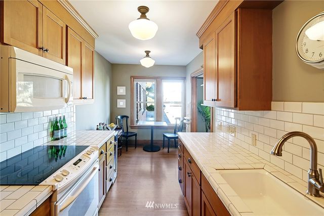 a large kitchen with stainless steel appliances granite countertop a lot of cabinets a stove and a wooden floors