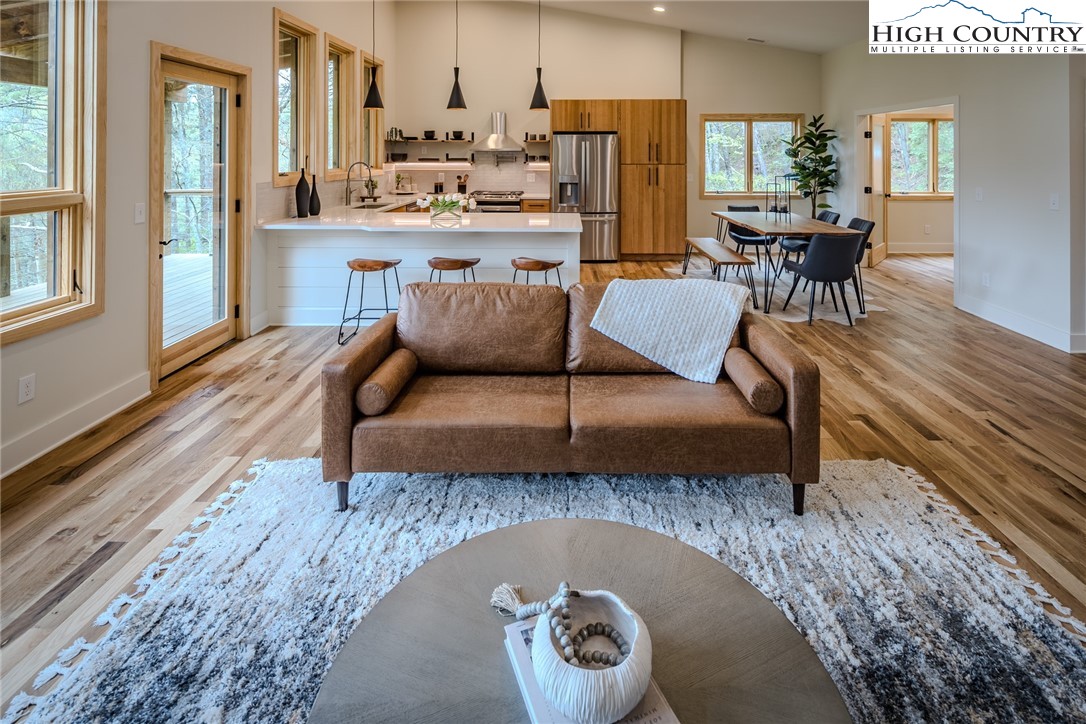 281 New Riv Farms Road Fleetwood, NC 28626 - Photo 11 of 50 a living room with stainless steel appliances granite countertop a couch a dining table and chairs with wooden floor