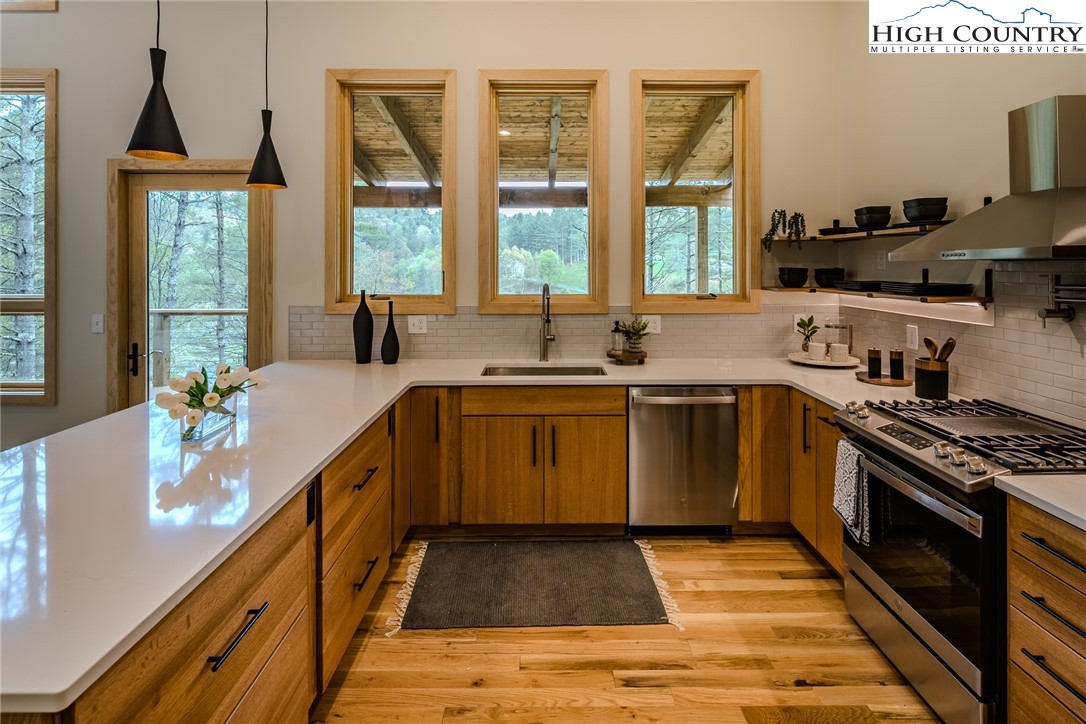281 New Riv Farms Road Fleetwood, NC 28626 - Photo 15 of 50 a kitchen with a sink stove and cabinets