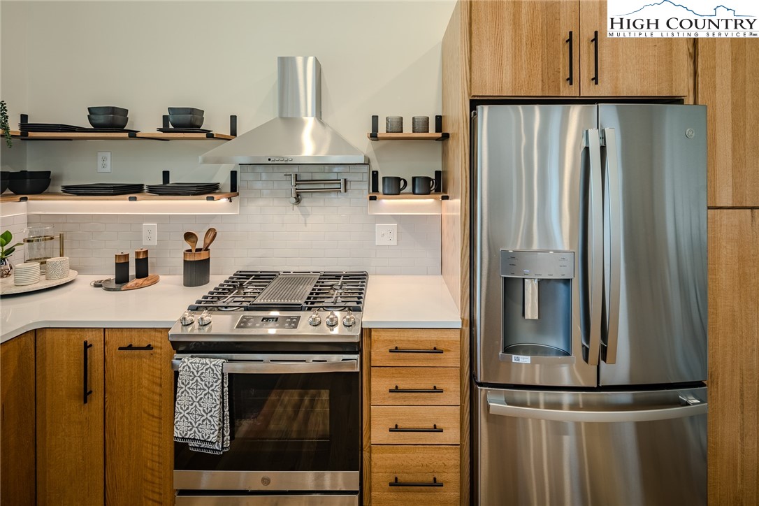 281 New Riv Farms Road Fleetwood, NC 28626 - Photo 16 of 50 a kitchen with stainless steel appliances granite countertop a refrigerator stove and sink