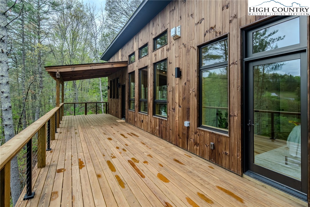 281 New Riv Farms Road Fleetwood, NC 28626 - Photo 42 of 50 a view of balcony with floor to ceiling windows and wooden floor