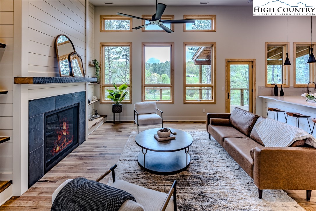 281 New Riv Farms Road Fleetwood, NC 28626 - Photo 9 of 50 a living room with furniture a fireplace and a large window