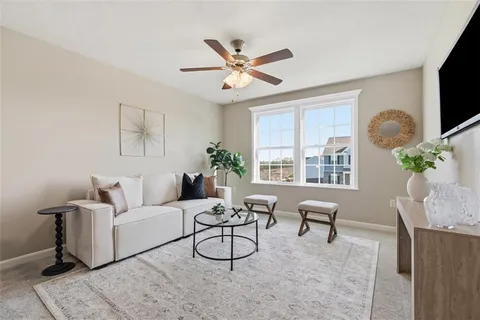 a living room with furniture a flat screen tv and a window