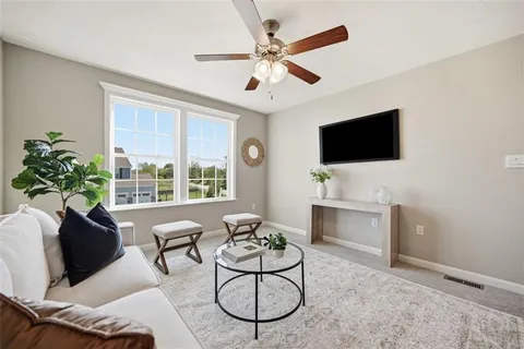 a living room with furniture a flat screen tv and a large window