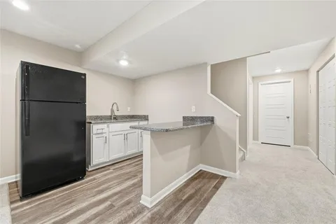 a kitchen with white cabinets and refrigerator