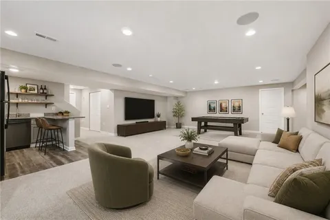 a living room with furniture kitchen view and a flat screen tv