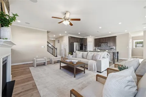 a living room with furniture kitchen view and a chandelier