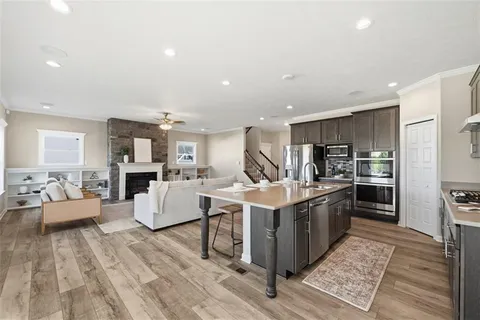 a kitchen with stainless steel appliances kitchen island granite countertop a stove and a refrigerator