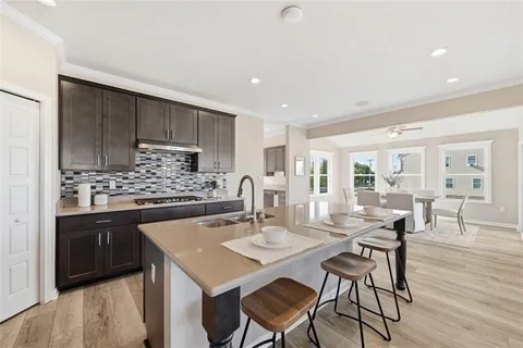 a kitchen with a dining table chairs and wooden floor