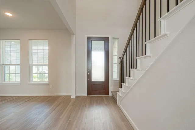 a view of an entryway with wooden floor and stairs
