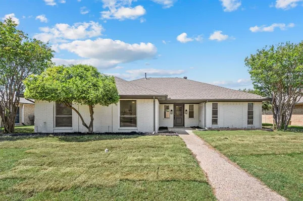 a front view of house with yard and trees around