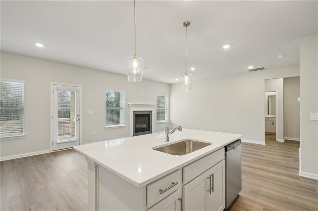 1458 High Fls Lane Grayson, GA 30017 - Photo 11 of 42 a kitchen with a sink dishwasher a stove and a refrigerator with wooden floor