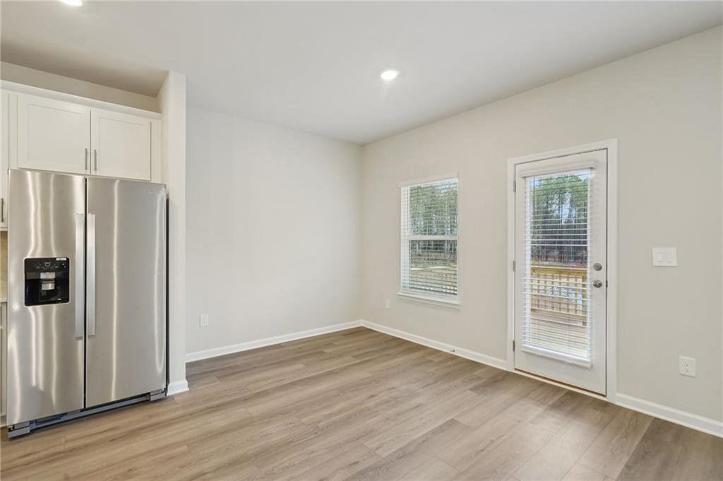 1458 High Fls Lane Grayson, GA 30017 - Photo 12 of 42 a view of a kitchen with wooden floor and a refrigerator