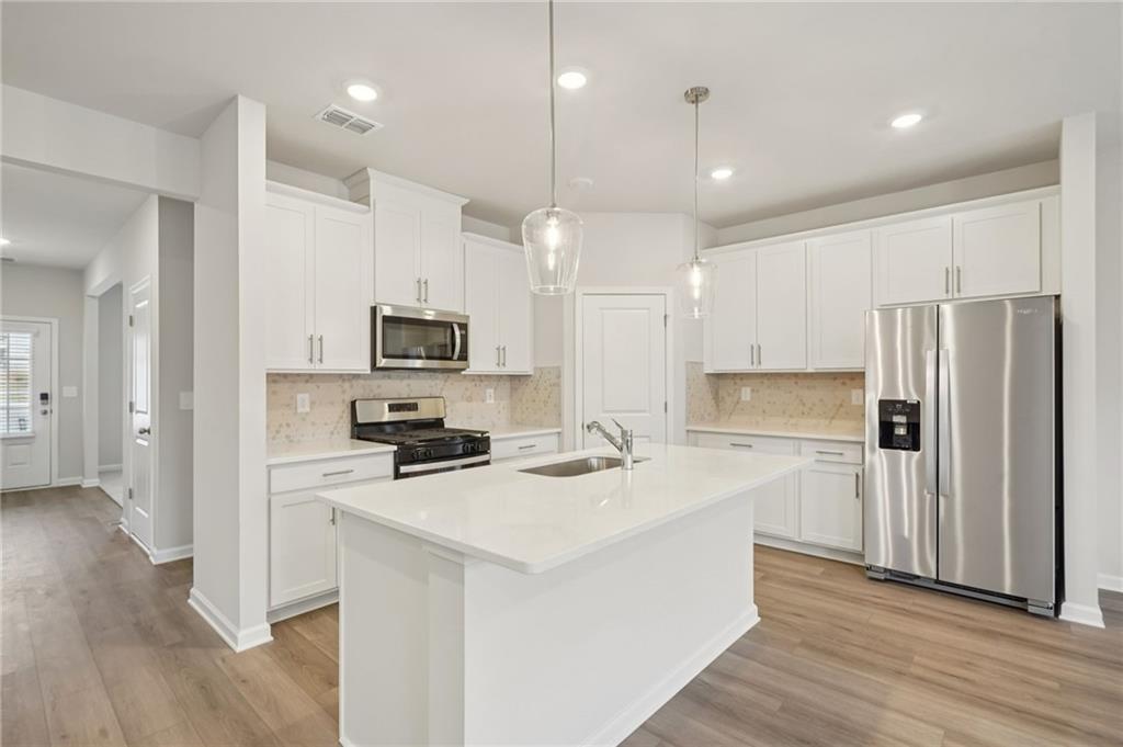 1458 High Fls Lane Grayson, GA 30017 - Photo 9 of 42 a kitchen with stainless steel appliances a refrigerator stove microwave and cabinets