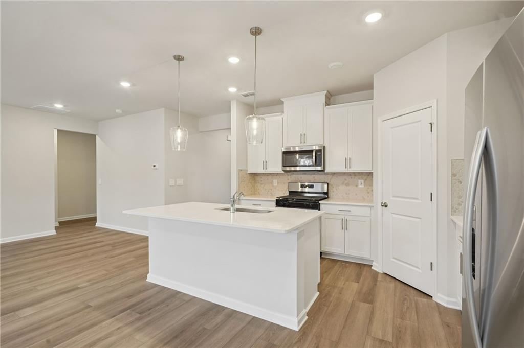 1458 High Fls Lane Grayson, GA 30017 - Photo 10 of 42 a kitchen with stainless steel appliances a refrigerator a stove top oven and a center island