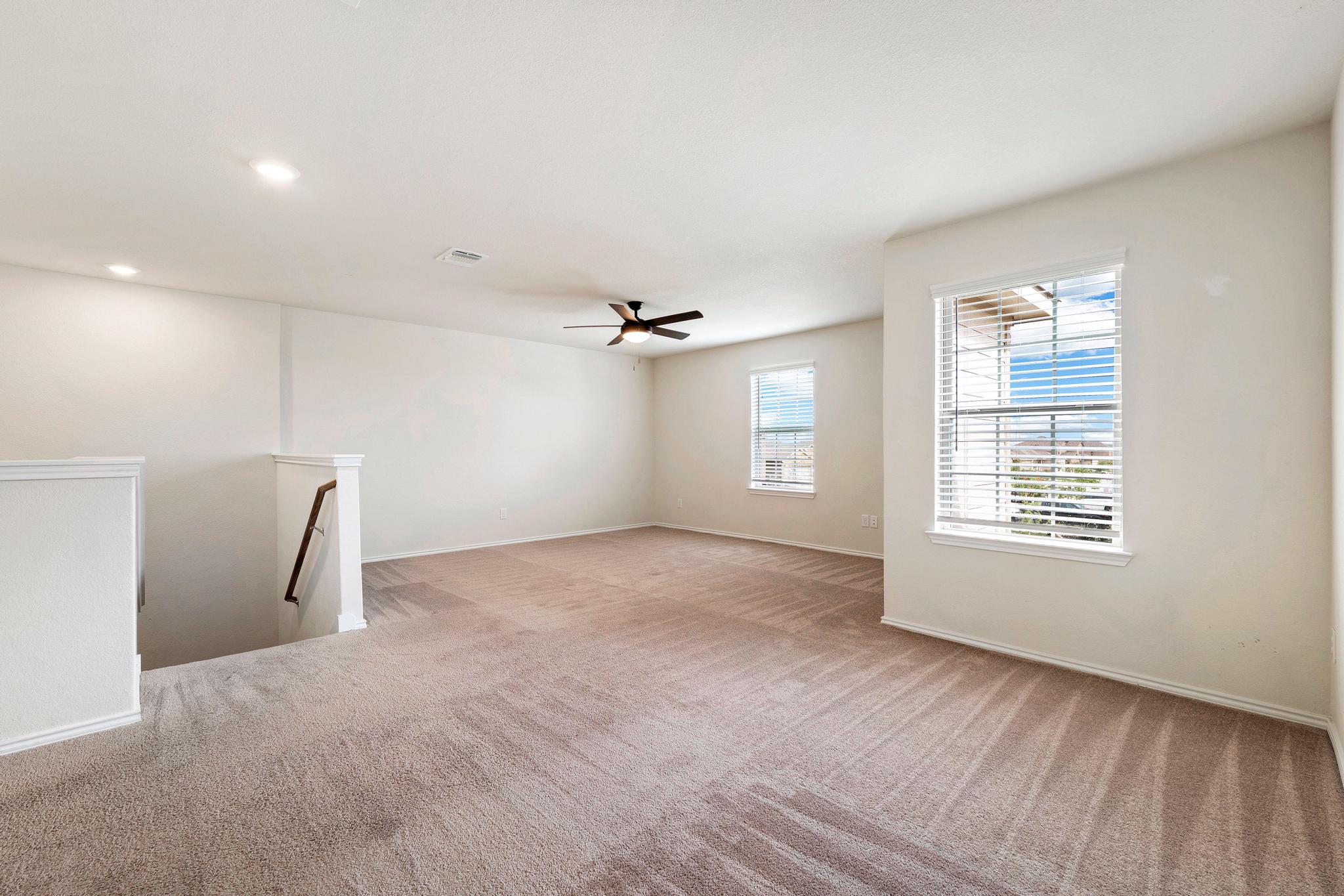 217 Innisfree Road Jarrell, TX 76537 - Photo 19 of 39 A spacious upstairs loft provides flexible living space with carpeted flooring and abundant natural light.
