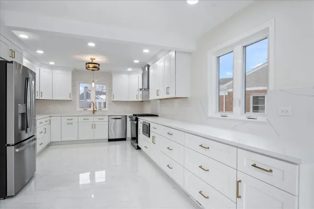a kitchen with white cabinets stainless steel appliances and a sink