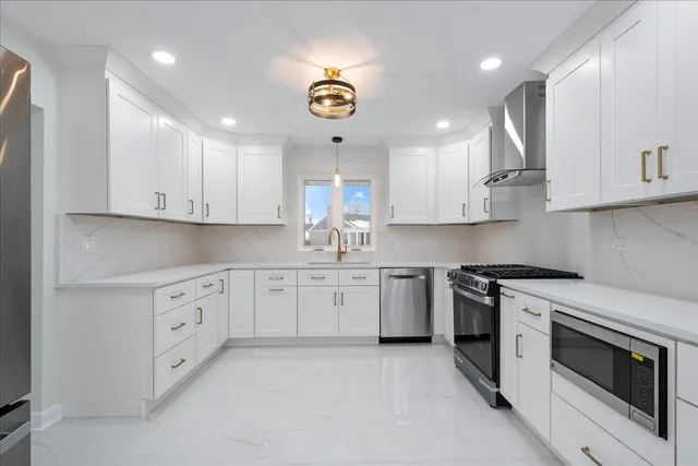 a kitchen with stainless steel appliances granite countertop a sink and a stove