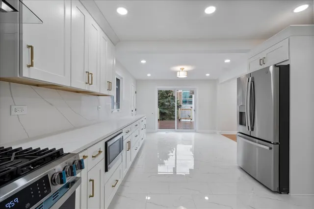 a kitchen with stainless steel appliances a refrigerator and a stove top oven