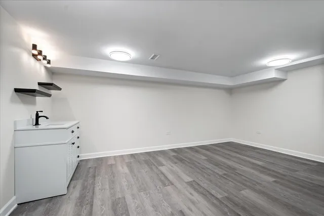 a view of a room with wooden floor and a sink