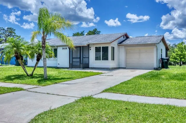 a front view of a house with a garden and trees