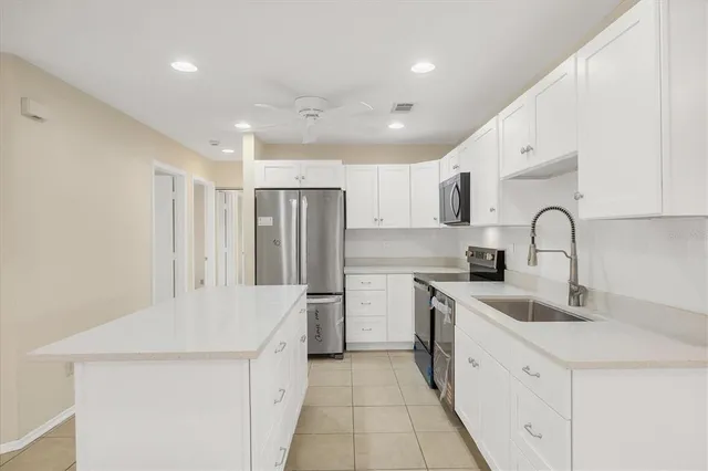 a kitchen with a sink a refrigerator and cabinets