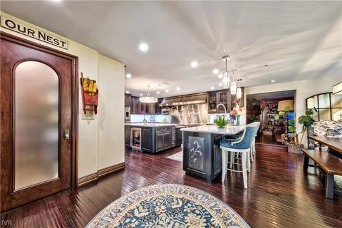 a living room with stainless steel appliances kitchen island granite countertop furniture wooden floor and a rug