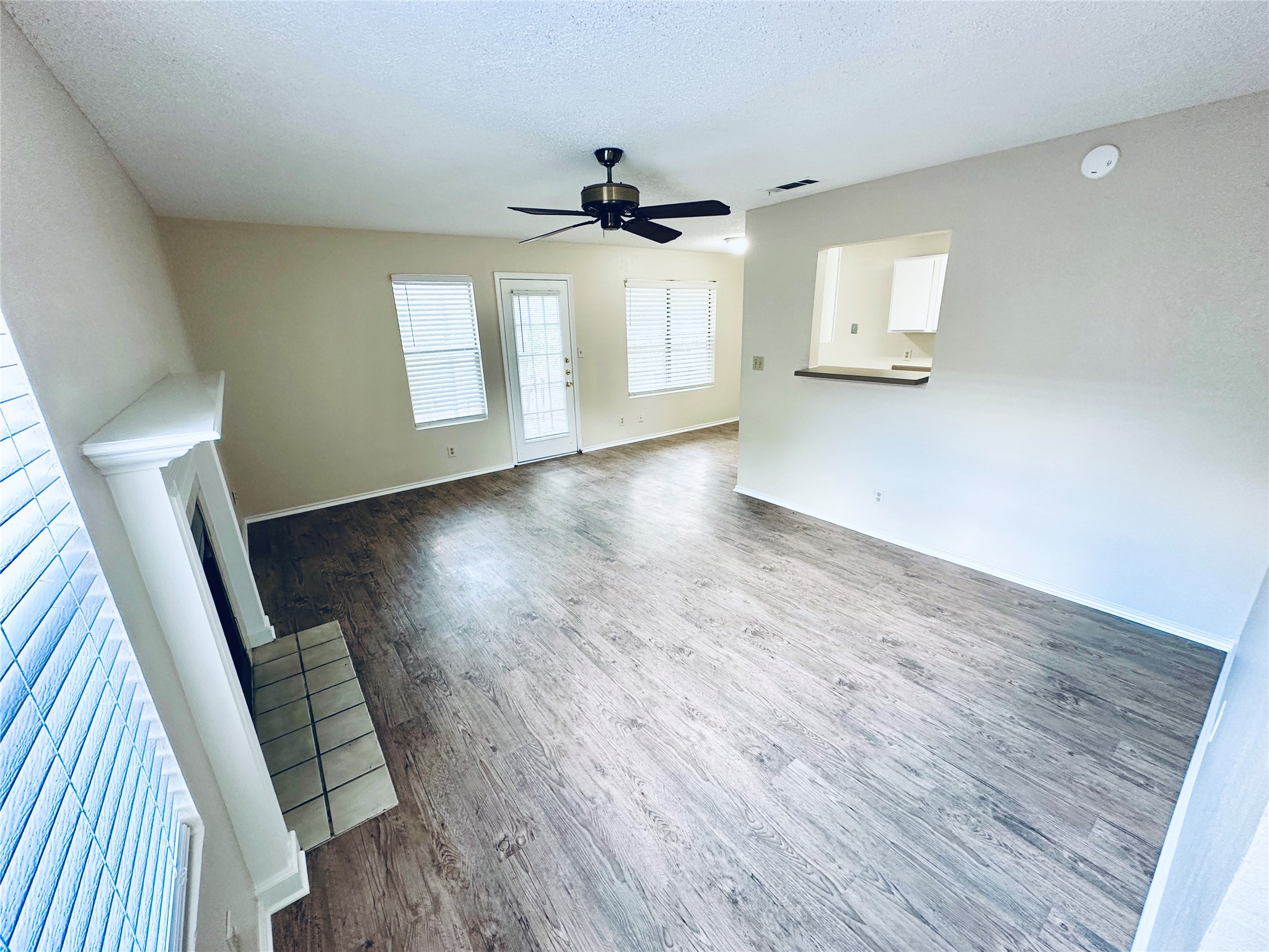 379 Fantail Loop, Unit B Austin, TX 78734 - Photo 4 of 33 An open layout connects the living space with wood-style flooring to the kitchen pass-through.