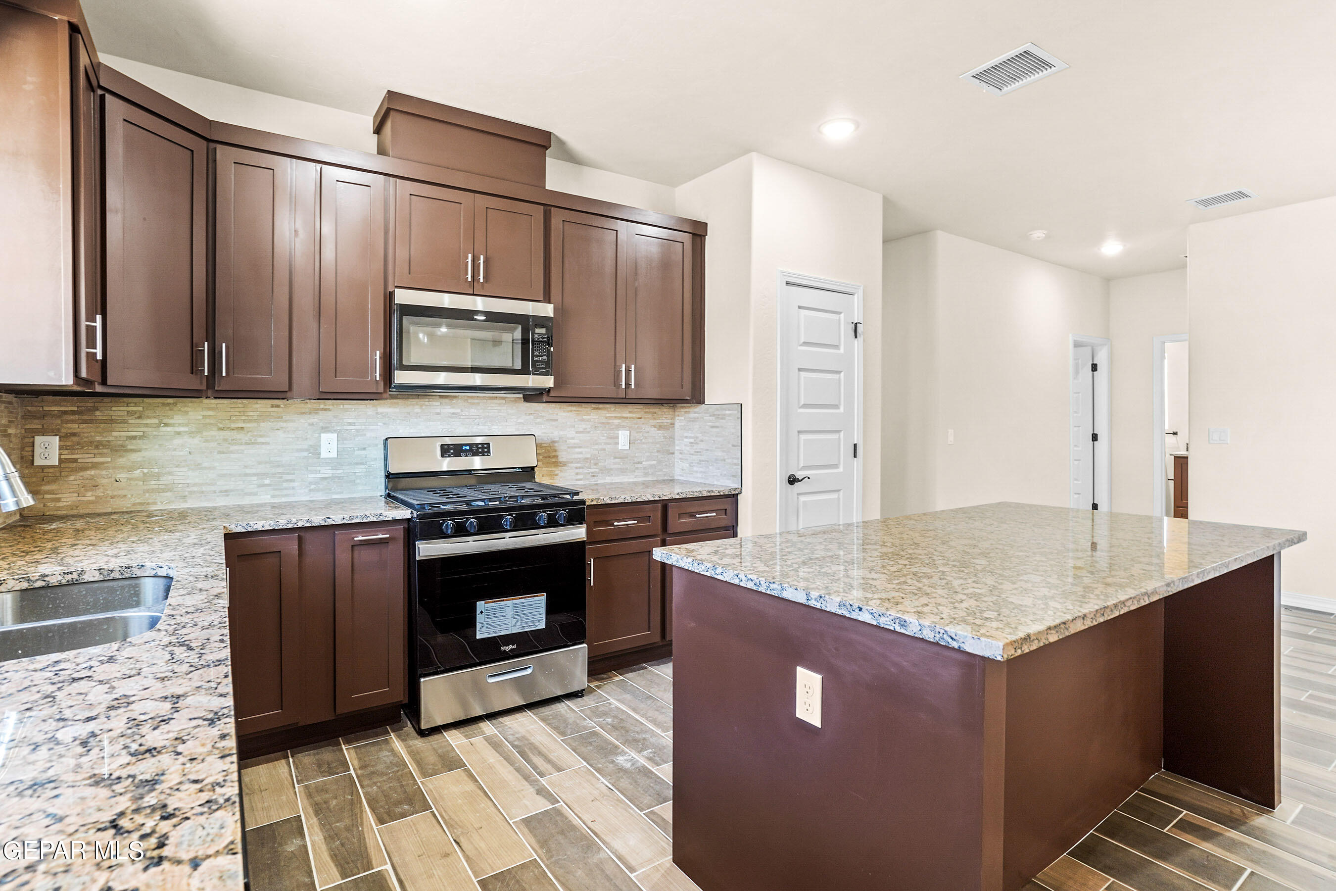 871 Country Club Road, Unit 4E El Paso, TX 79932 - Photo 1 of 34 a kitchen with stainless steel appliances granite countertop a stove a sink and a microwave