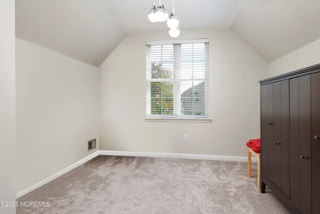 an empty room with a windows and chandelier fan