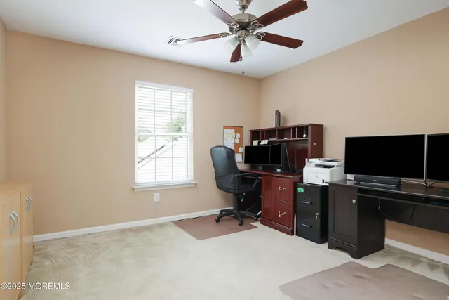 a view of a workspace with furniture and a window