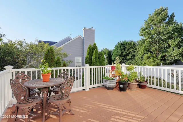a roof deck with table and chairs potted plants with wooden floor