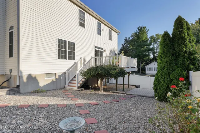 a view of a backyard with plants and a bench
