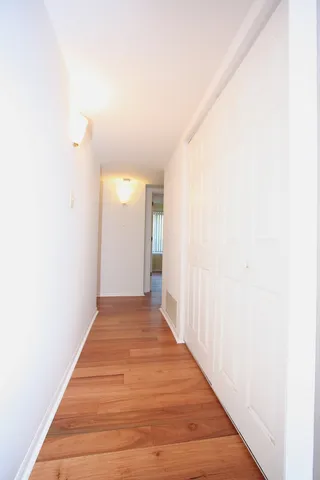 a view of a hallway with wooden floor