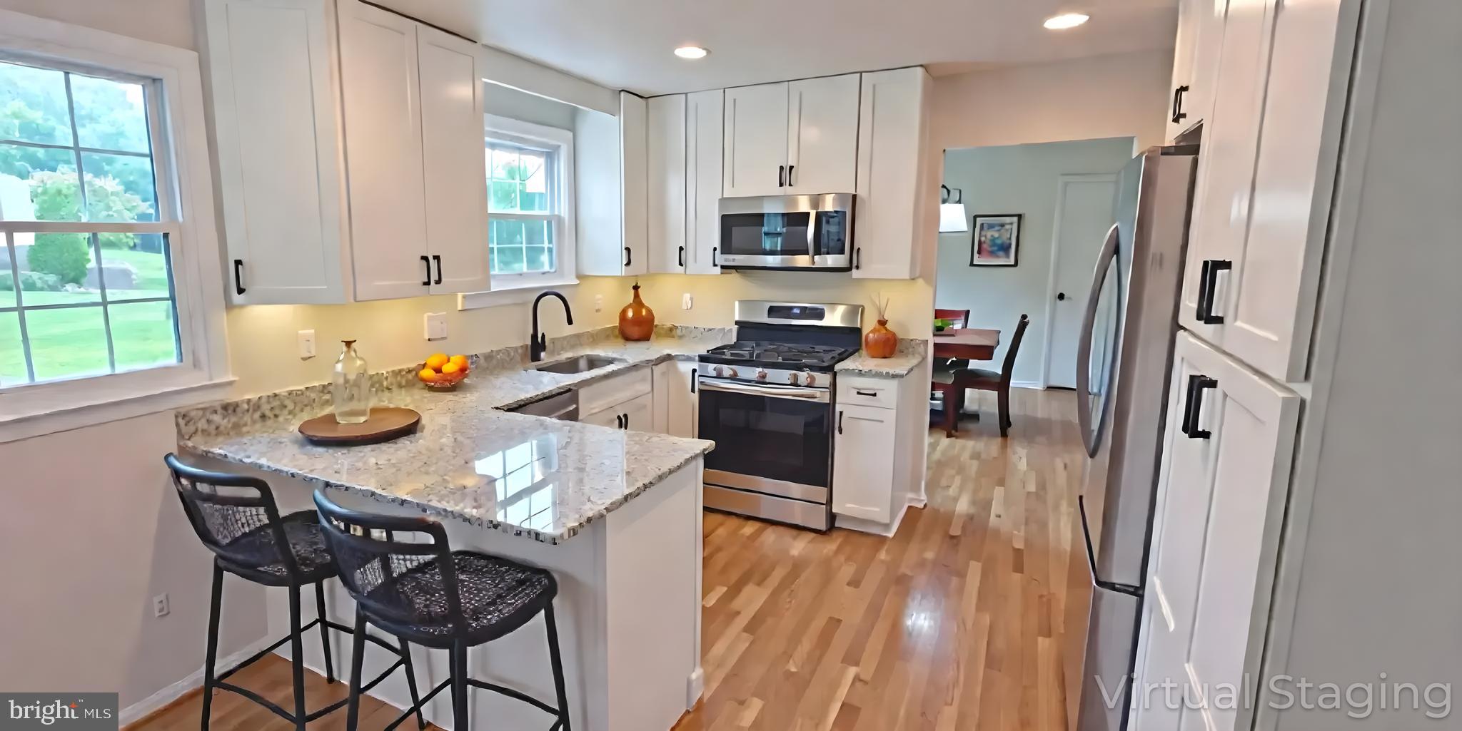 1900 Shetland Road Finksburg, MD 21048 - Photo 7 of 32 a kitchen with stainless steel appliances a table chairs refrigerator and microwave