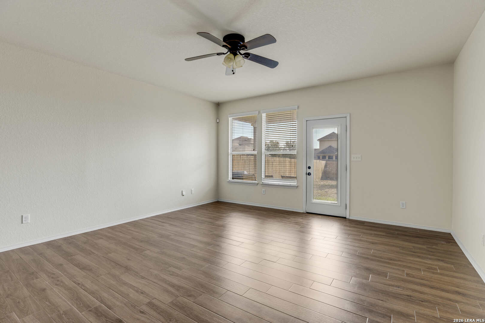322 Walnut Crest Selma, TX 78154 - Photo 16 of 33 an empty room with wooden floor chandelier fan and windows