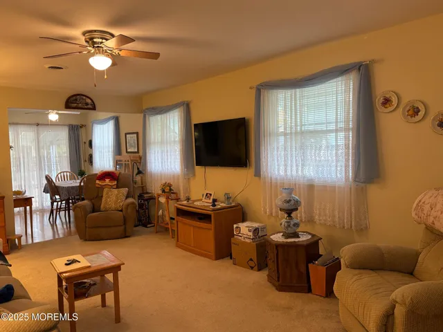 a living room with furniture a chandelier and a flat screen tv