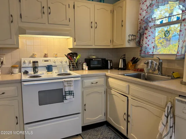 a kitchen with white cabinets and white appliances