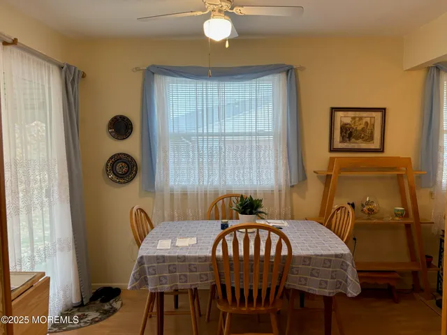 a view of a a dining room with furniture window and wooden floor