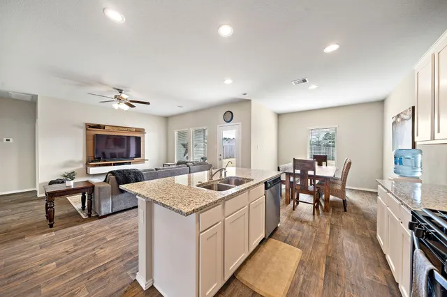 a very nice looking dining room with kitchen island a large counter space and furniture
