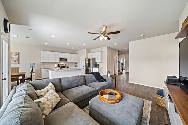 a living room with furniture kitchen view and a flat screen tv